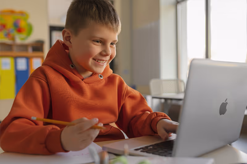 Young child concentrating while doing math for kids exercises on paper.