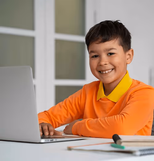 Young boy happily learning with Brainster's kids math tutoring program.