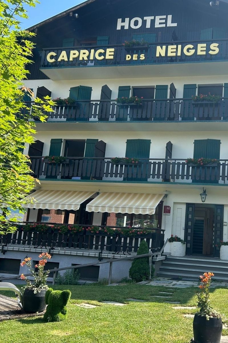 Entrance to the Caprice des Neiges hotel with traditional Alpine architecture in Combloux
