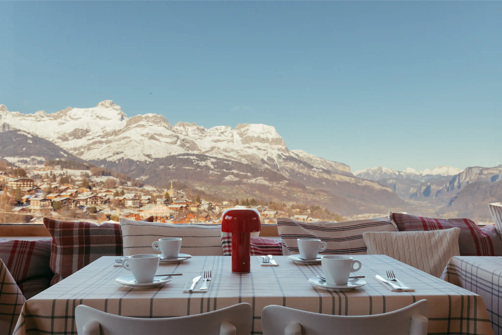 Petit-déjeuner servi au Caprice des Neiges avec vue sur les montagnes depuis la salle lumineuse.