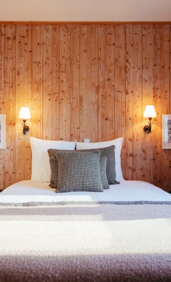 Double bed in a Superior Room at Le Caprice des Neiges, with wood decor and warm textiles.