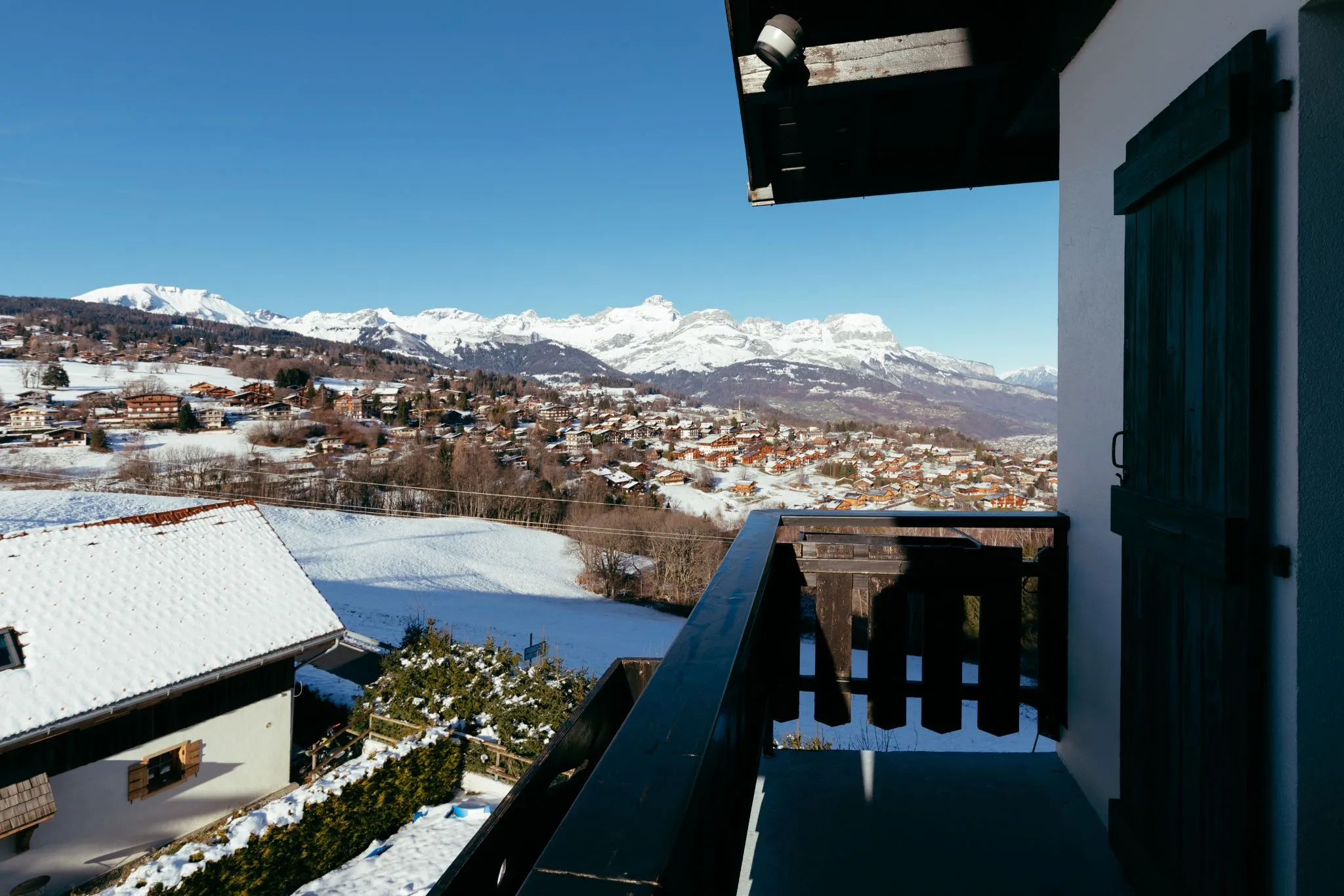 Balcon de l'hôtel Le Caprice des Neiges avec vue sur les montagnes de Combloux.