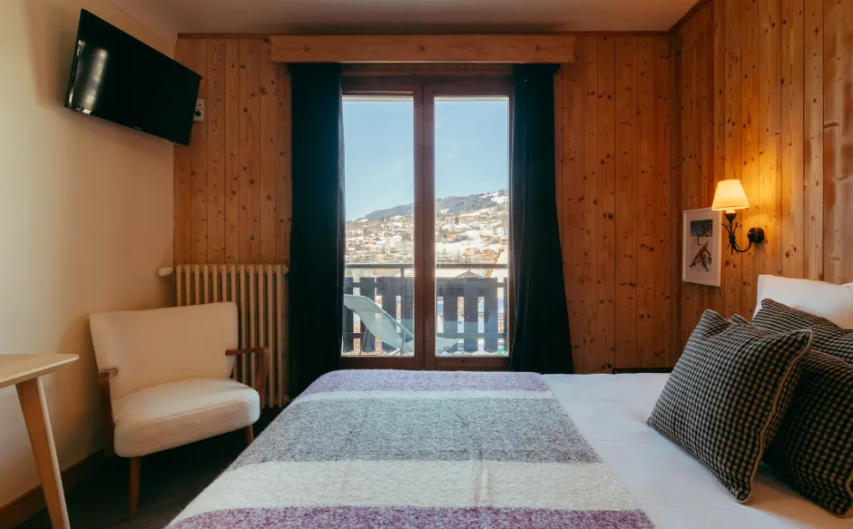 Superior room with private balcony at Caprice des Neiges, ideal for enjoying the Alpine scenery.
