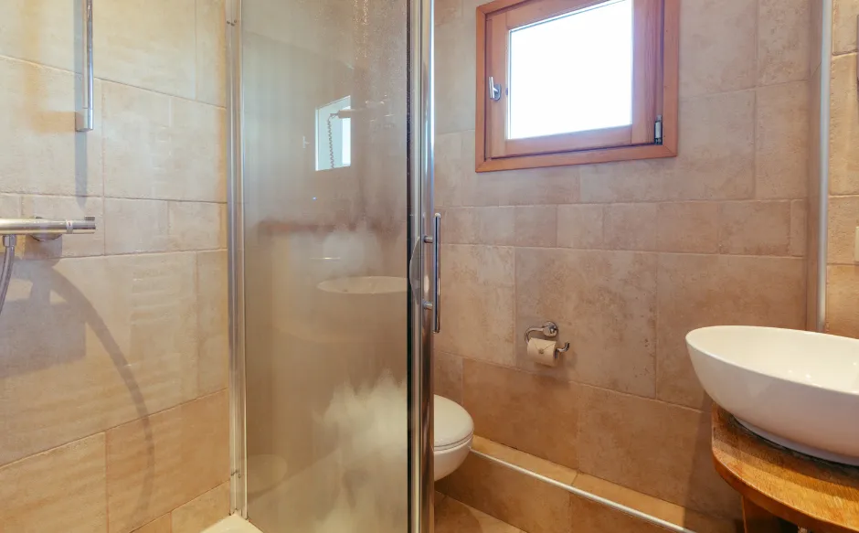 The bathroom of the Superior Room with balcony is equipped with a bathtub and decorated in a mountain style.