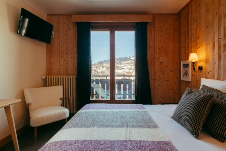 Bed with mountain views from the Balcony Superior Room at Le Caprice des Neiges.