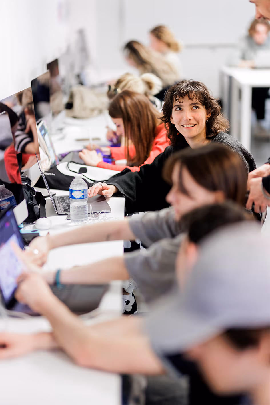 Young students working together on computers in a modern classroom.