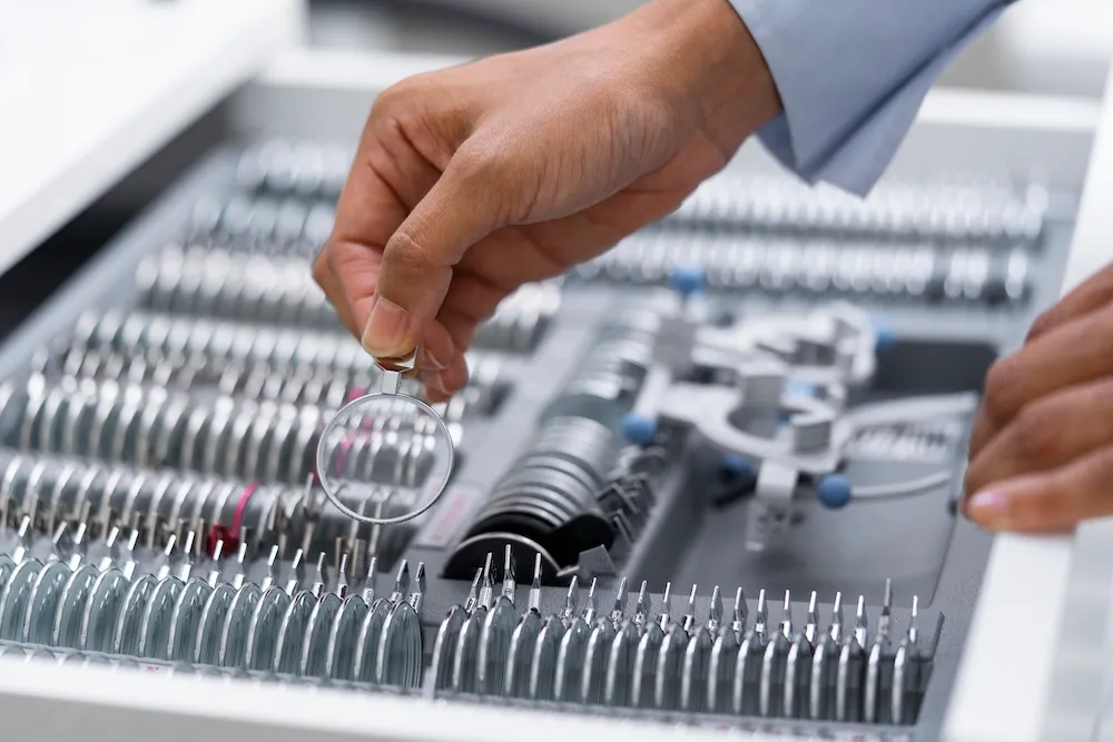 Optometrist selecting prescription lenses from optical equipment tray in Ontario eye care clinic