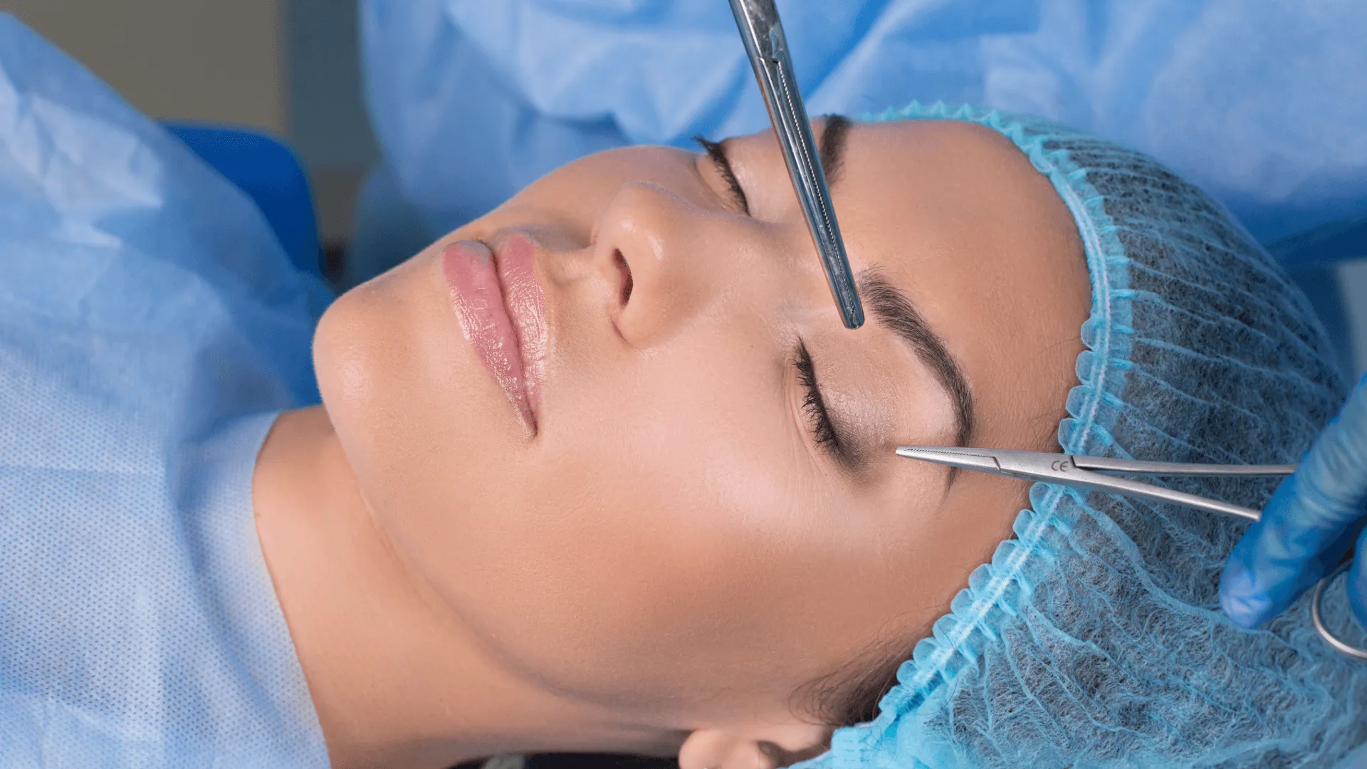 Surgeon performing cosmetic surgery on a woman in a surgical setting.