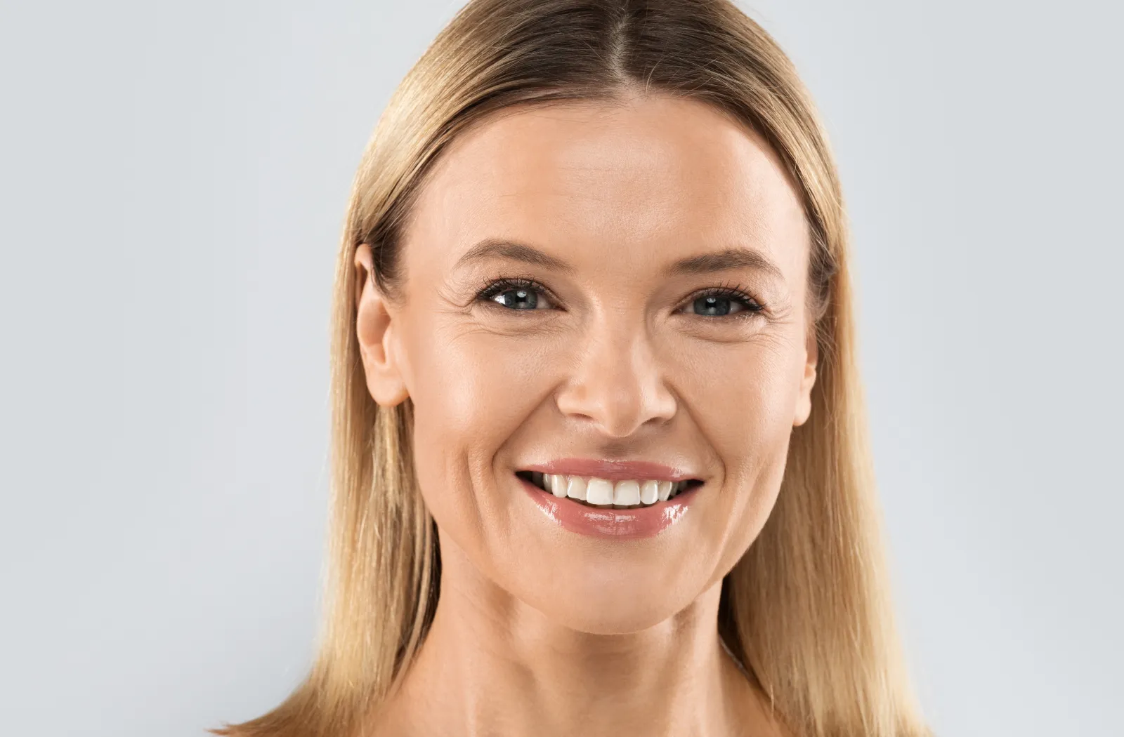 Smiling woman with straight blonde hair.