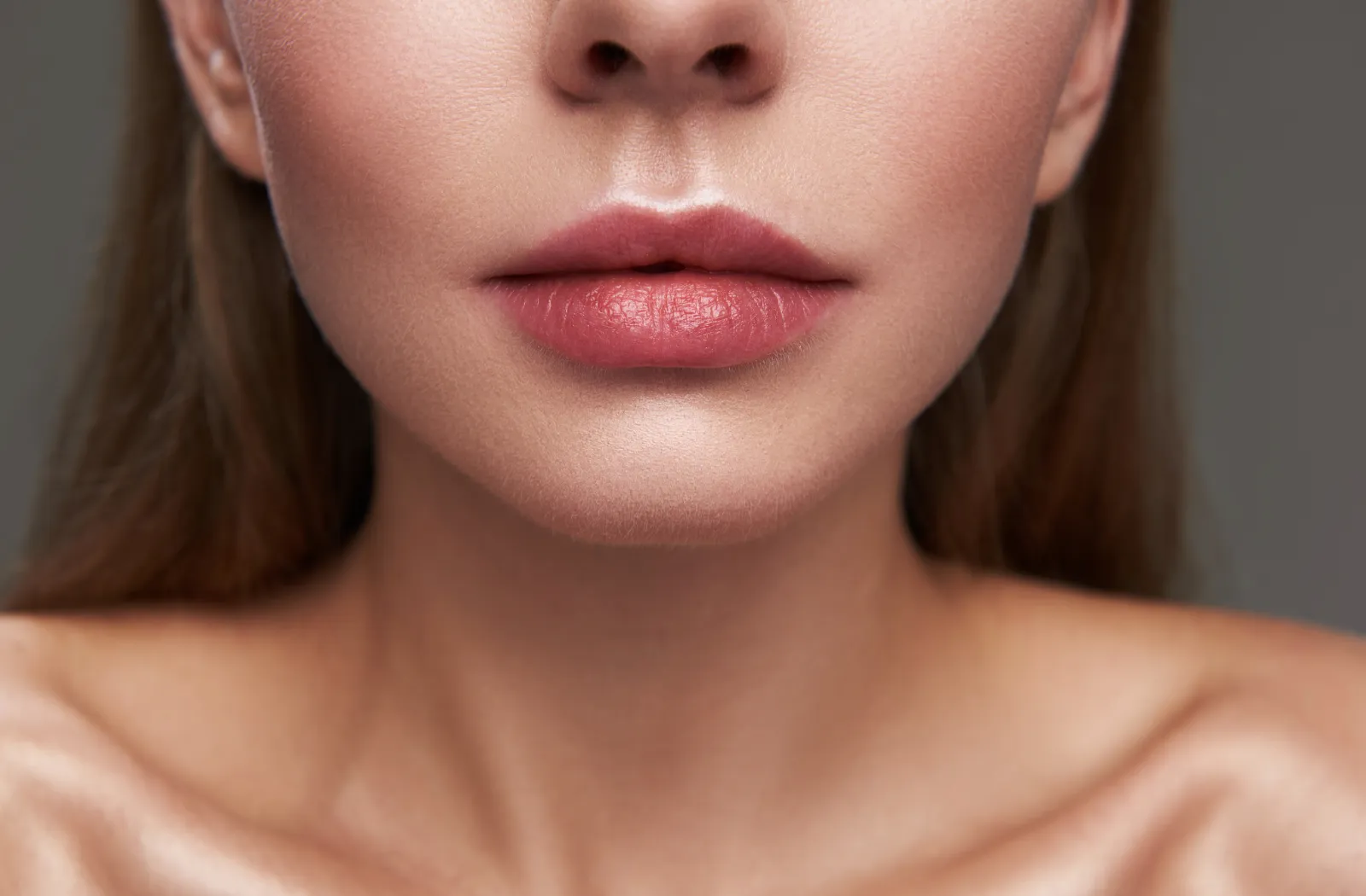 Close-up of a woman's lips and chin with smooth skin.