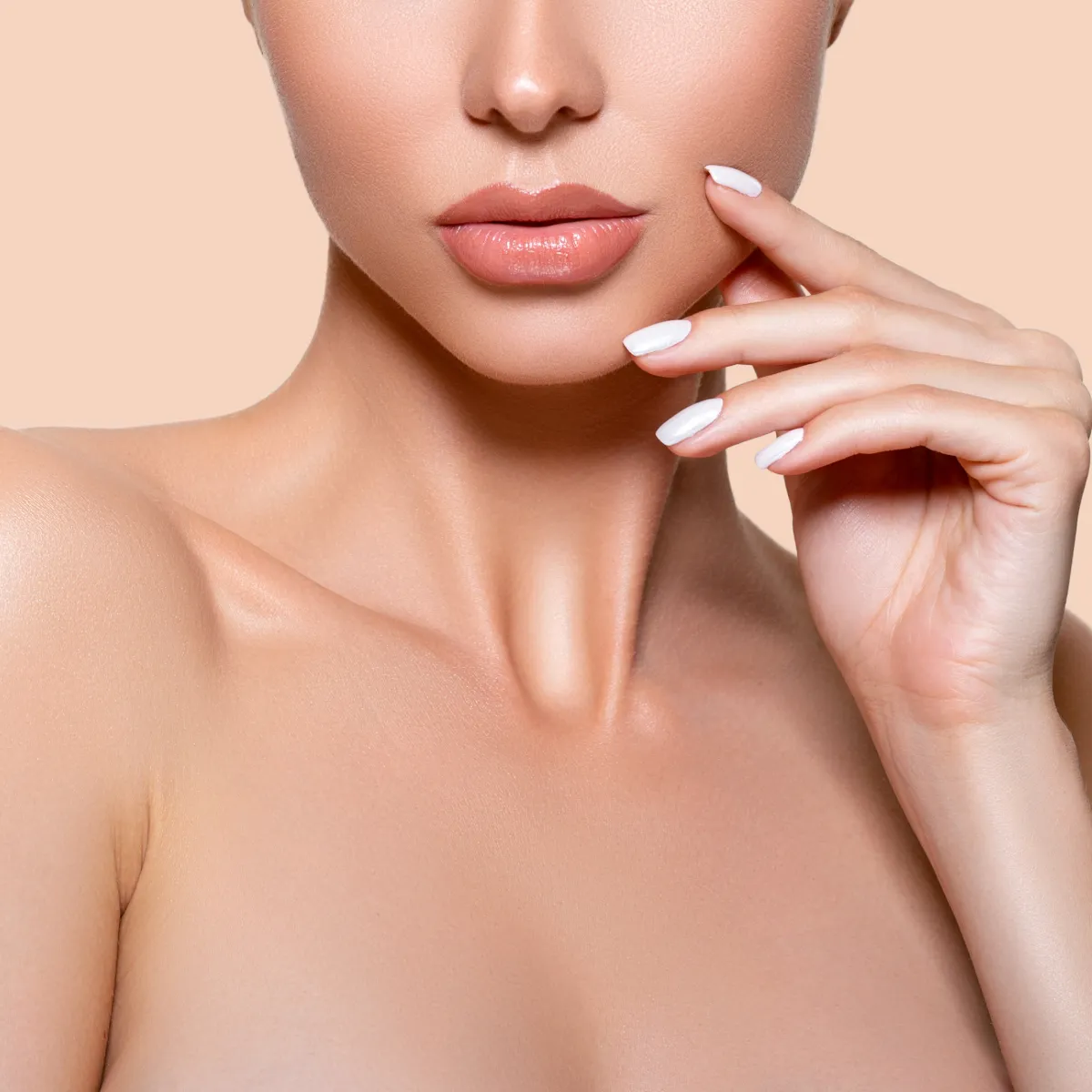 Close-up of a woman's face and hand with smooth skin and neutral makeup.