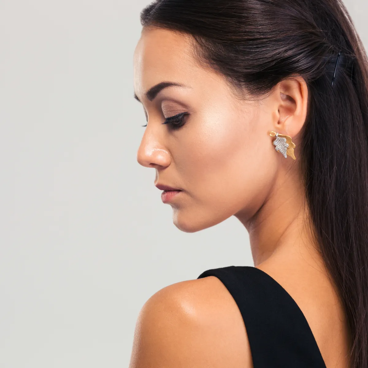 Profile of a woman with long hair and earrings.