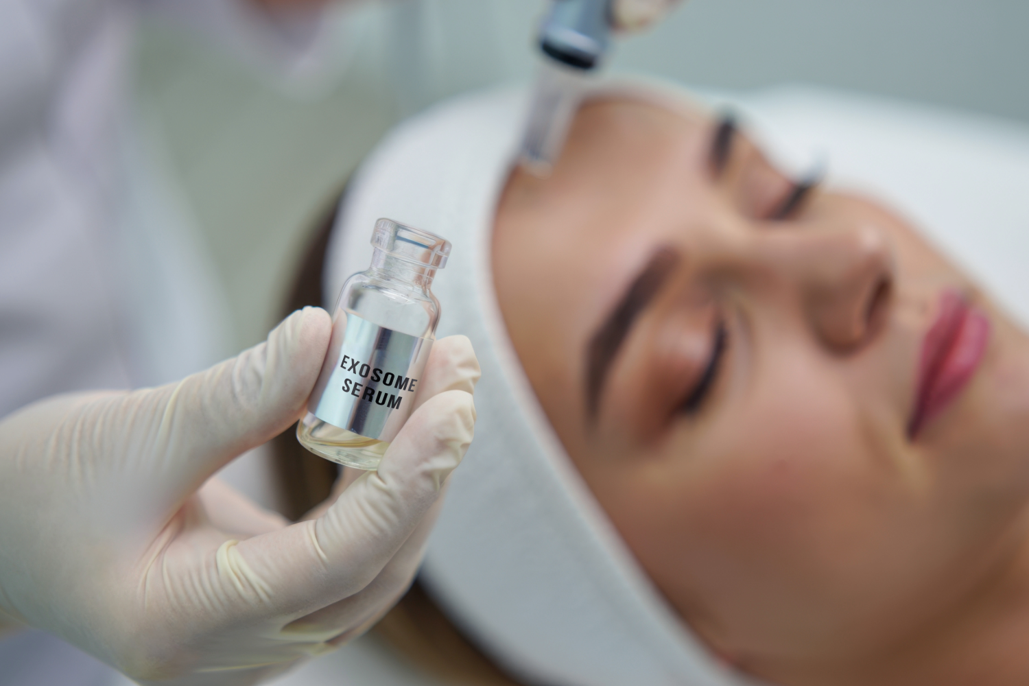 Esthetician performing a facial treatment on a woman in a spa, using skincare equipment for rejuvenation.