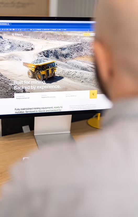 Website design for a mining and industrial company displayed on a desktop monitor, with a focus on large-scale yellow equipment in a quarry—capturing industry-focused digital design and rugged brand storytelling.