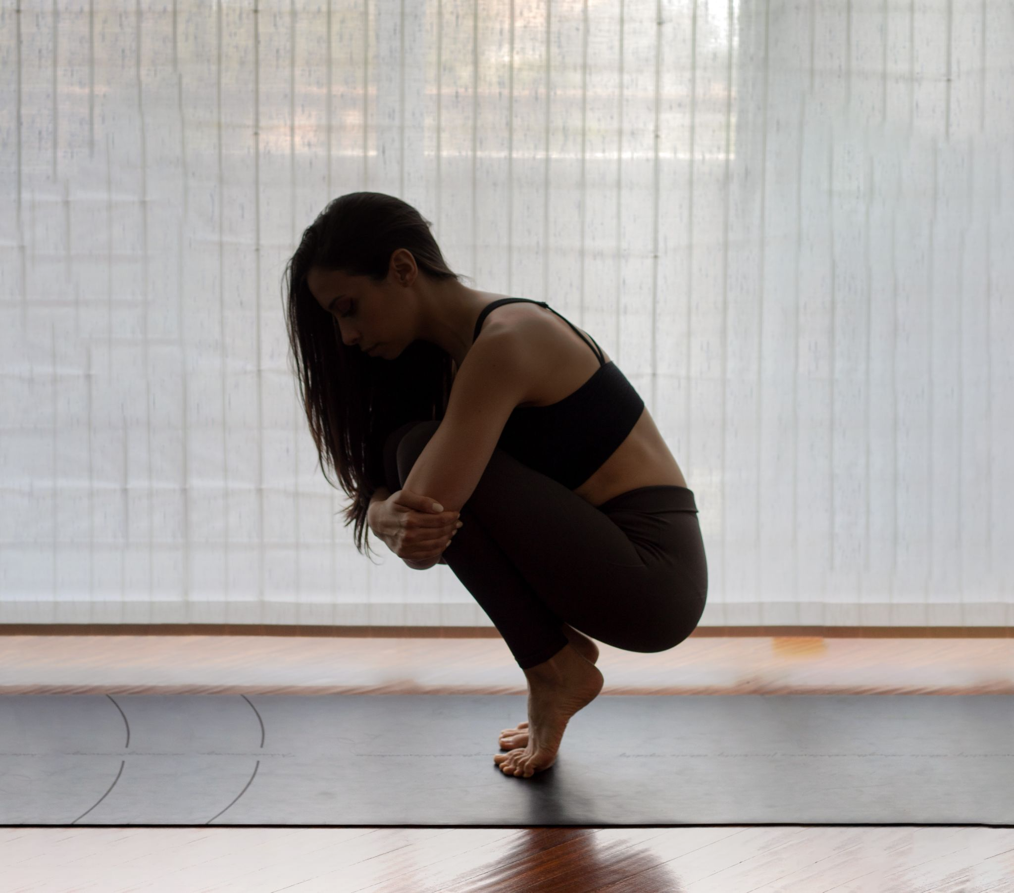 Une femme en train de faire du Yoga en équilibre afin de représenter l'équilibre qu'il faut adopter, en content marketing, entre création de contenu froid et création de contenu chaud pour réussir à construire une stratégie de contenu efficace