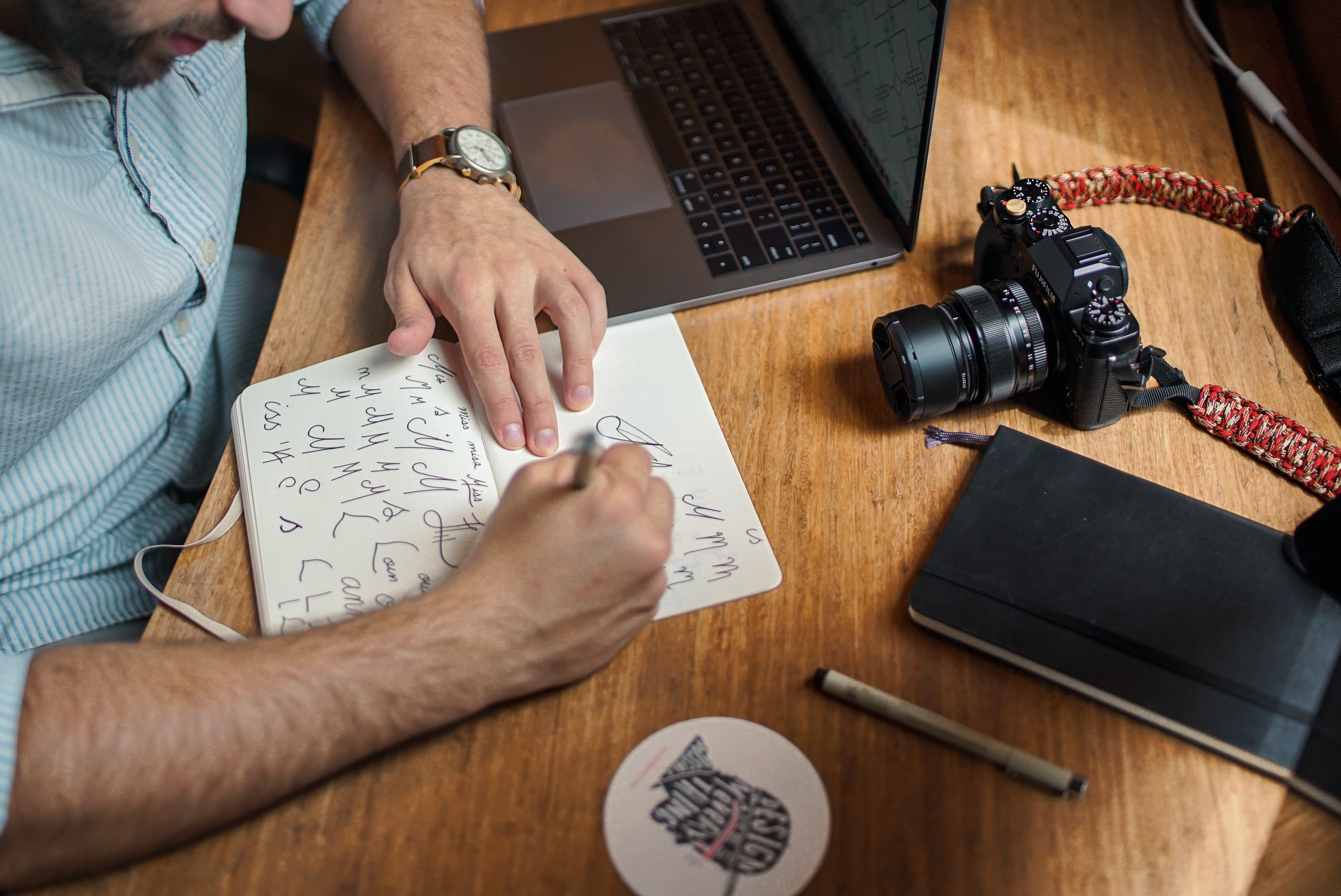 Illustration d'un graphiste qui réalise les croquis d'un logo sur un carnet pour l'article de HeySimon "Quand, comment et pourquoi faire évoluer son identité visuelle à travers un rebranding"