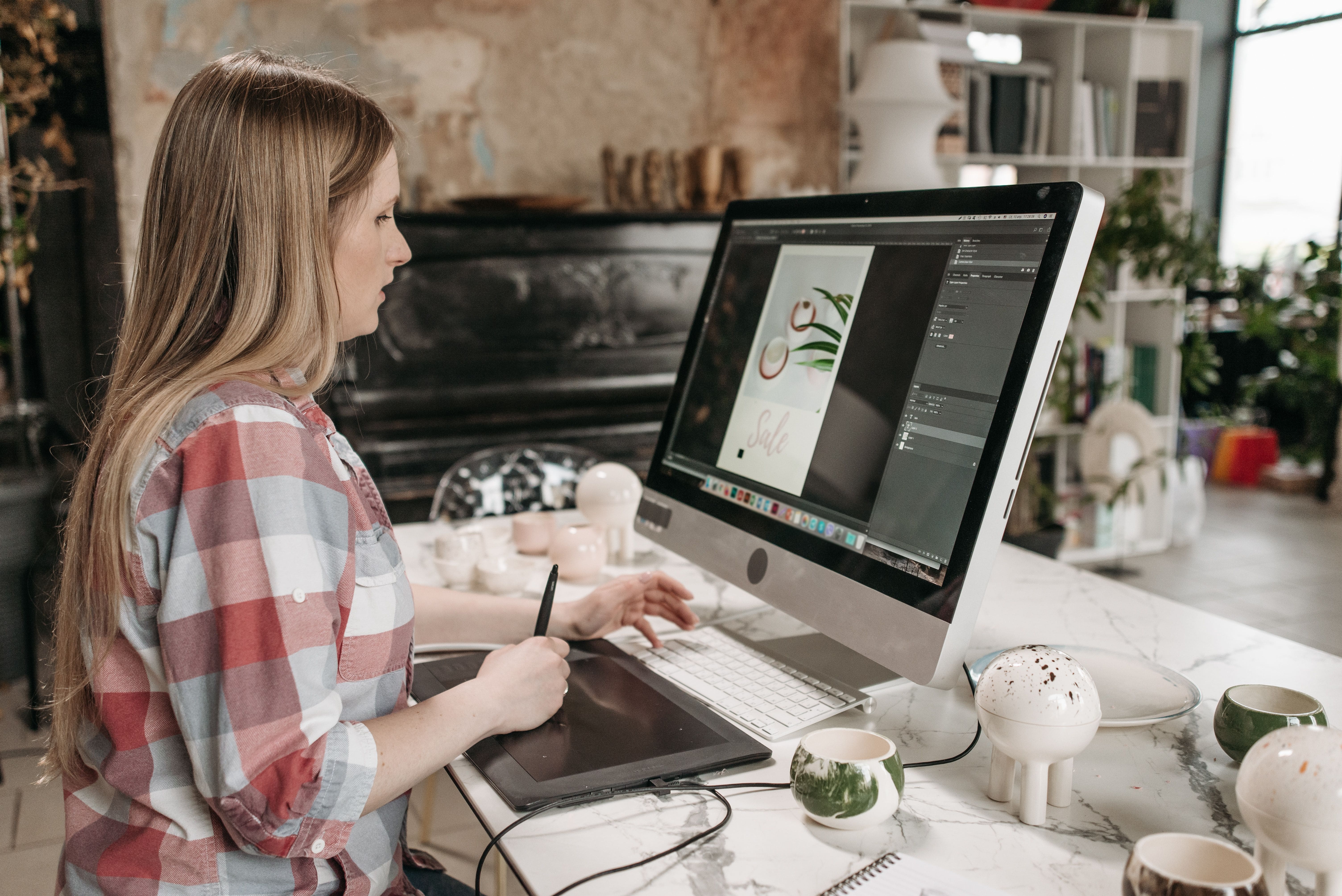 Graphiste au travail sur un iMac avec une tablette graphique