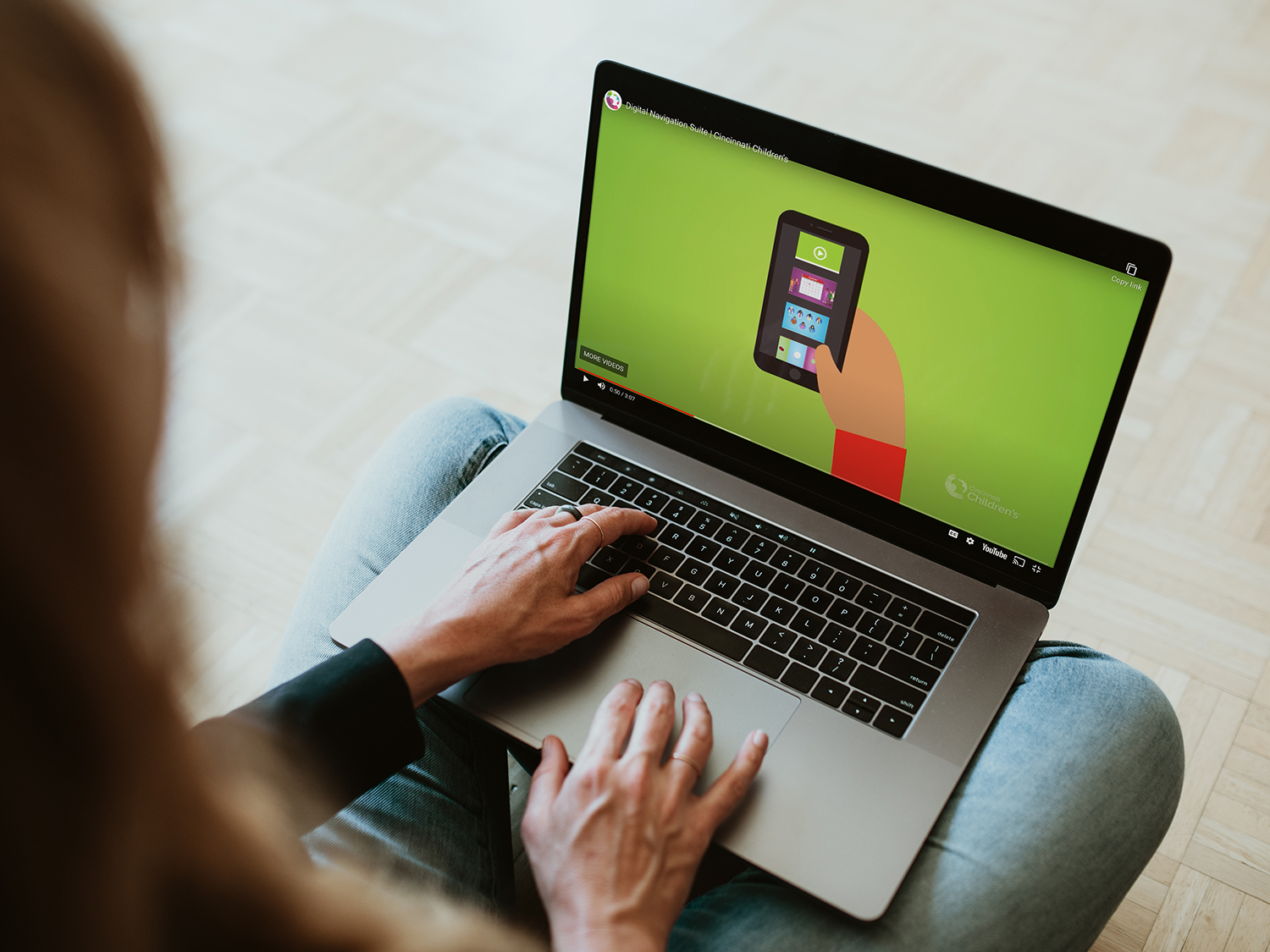 An adult watching a video on their laptop