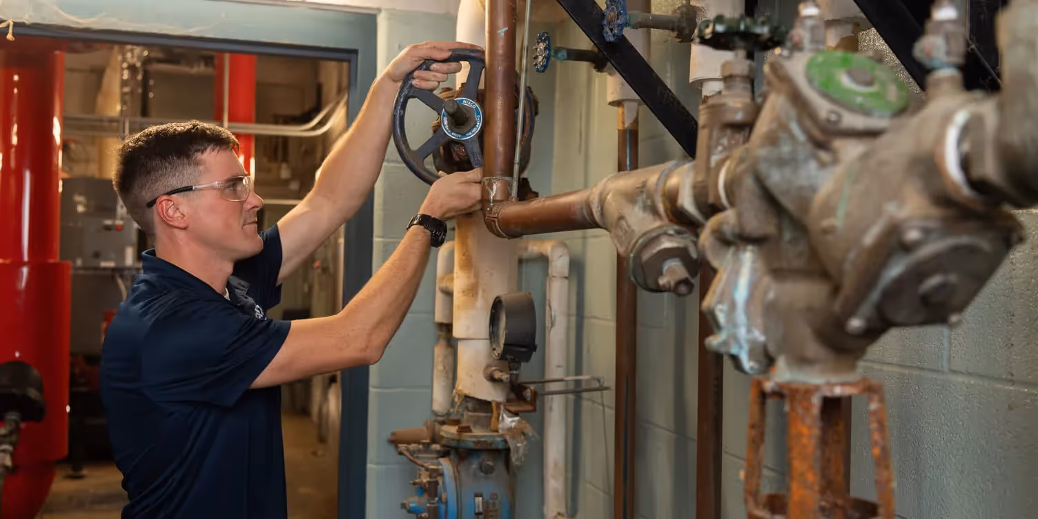 Technician fixing the pipes wearing dark blue shi