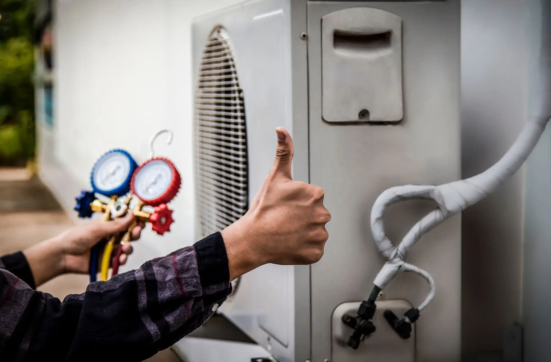 Air conditioning repair with gauges and thumbs-up.