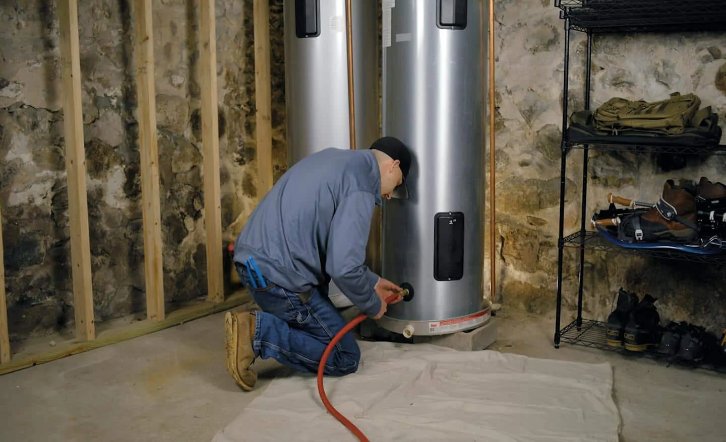Man flushing sediment from water heater.