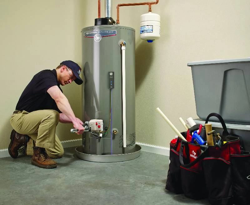 Man installing a tank water heater.