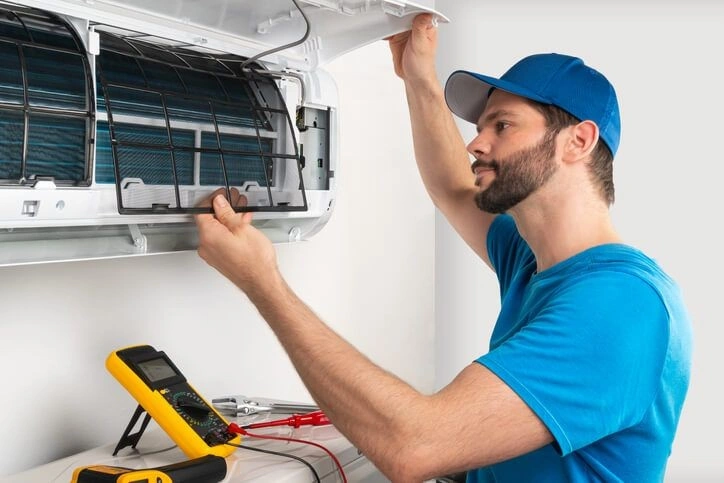 A person replacing a mini split AC unit.