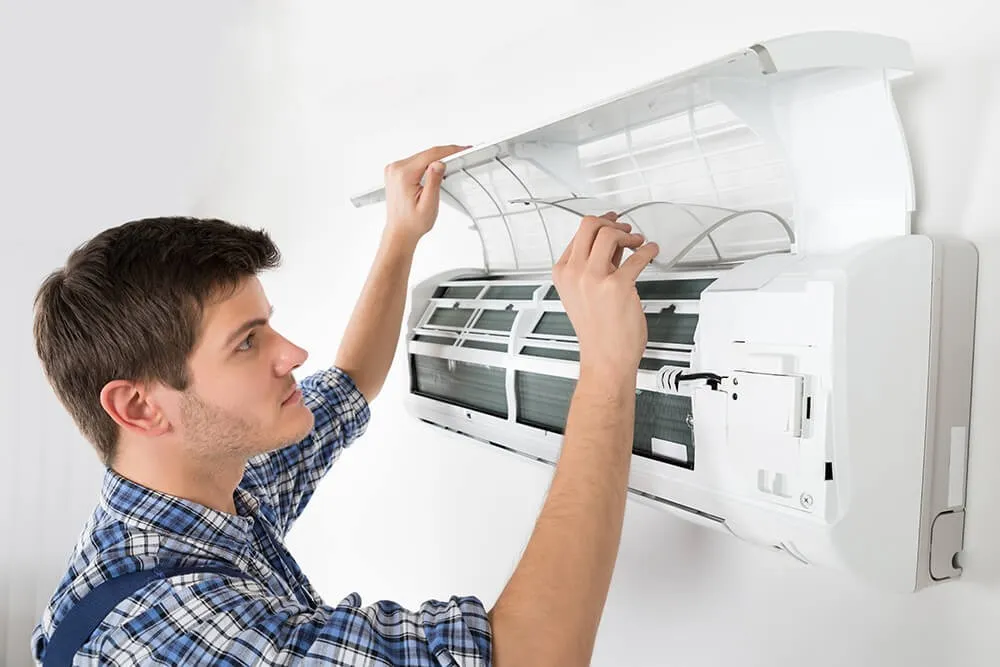 A professional replacing an indoor AC unit.