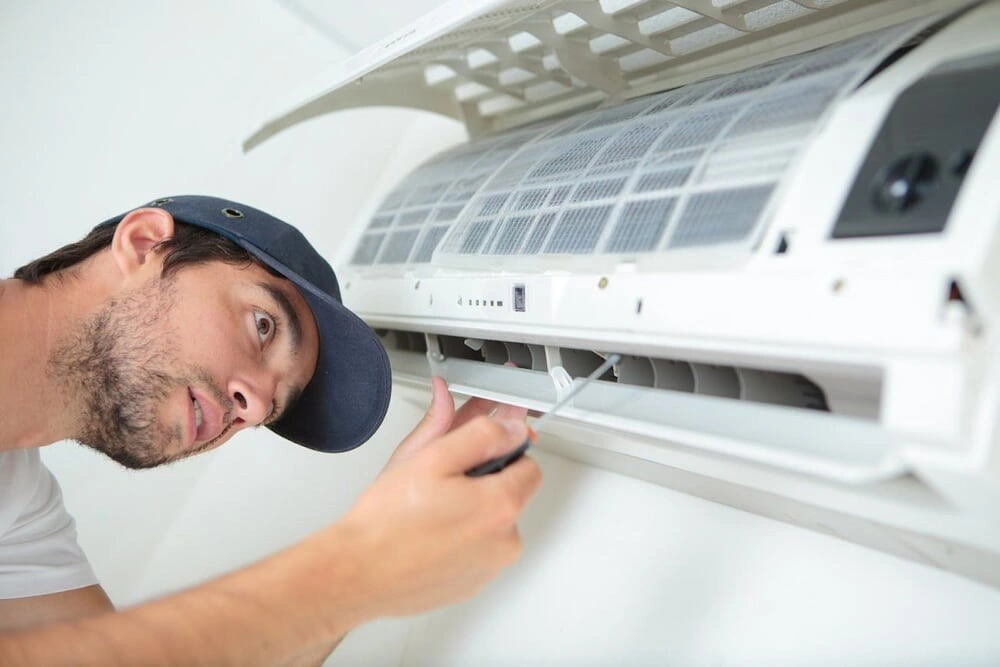 A technician replacing an air conditioner.