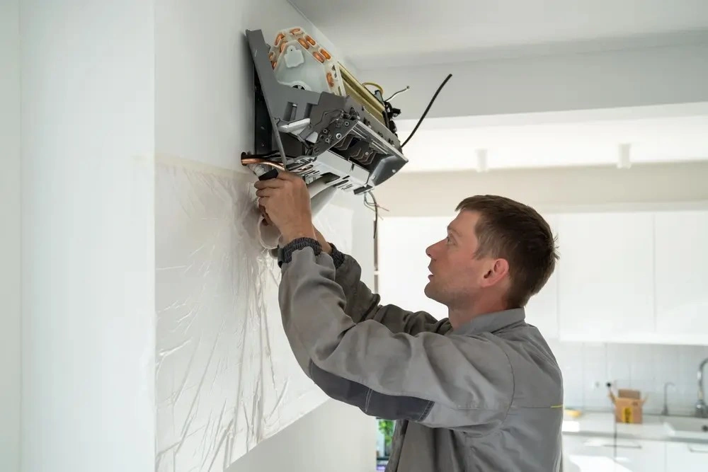 A professional replacing a mini split AC unit.
