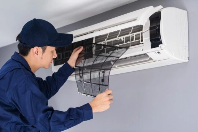 A man cleaning an air conditioner.