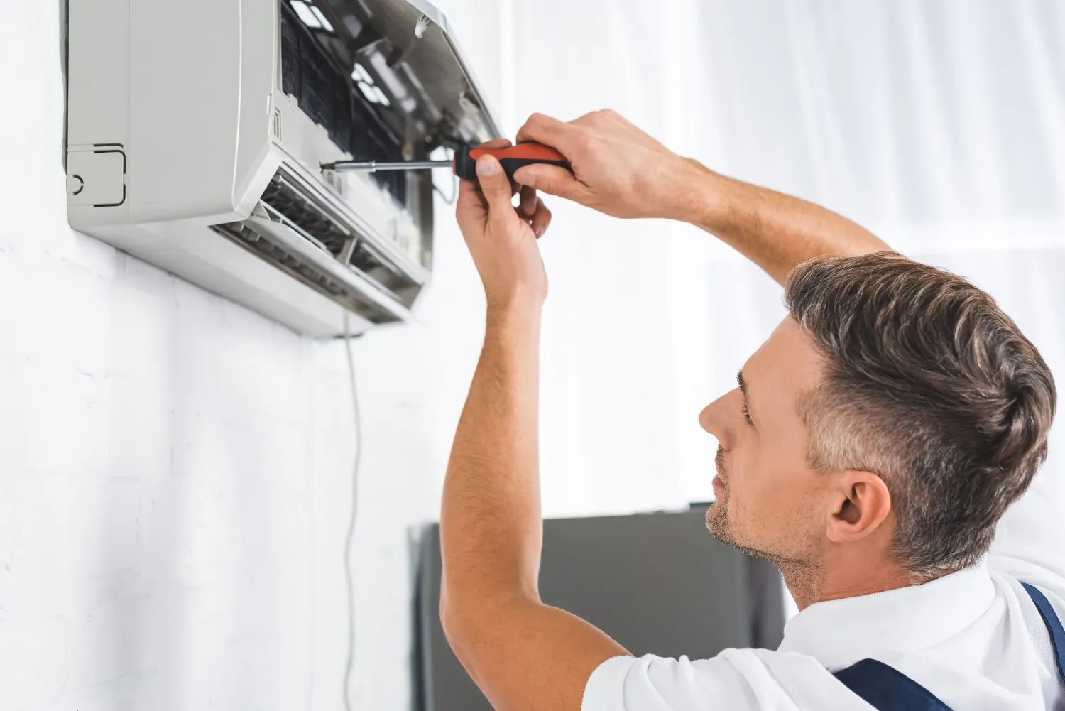 A technician repairing a mini-split AC.