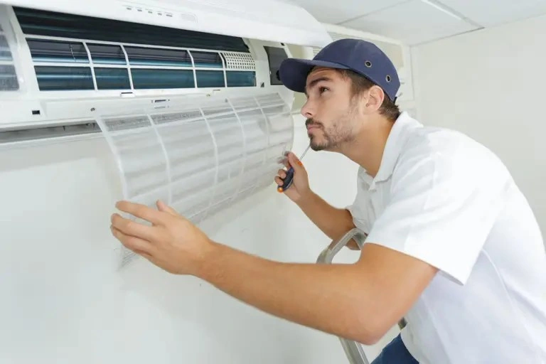 A repairman servicing a mini-split AC unit.