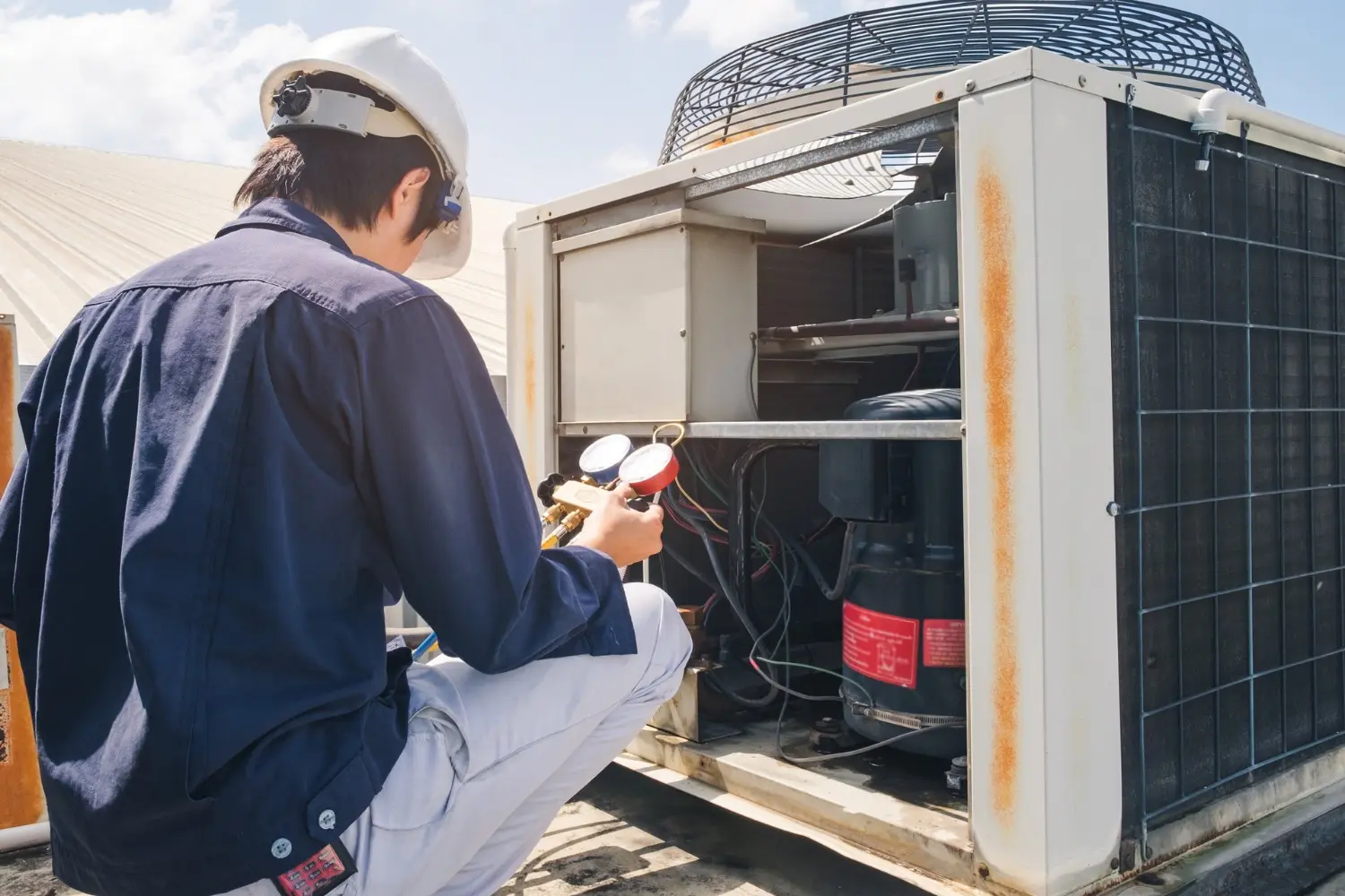 Technician checks pressures on commercial AC.