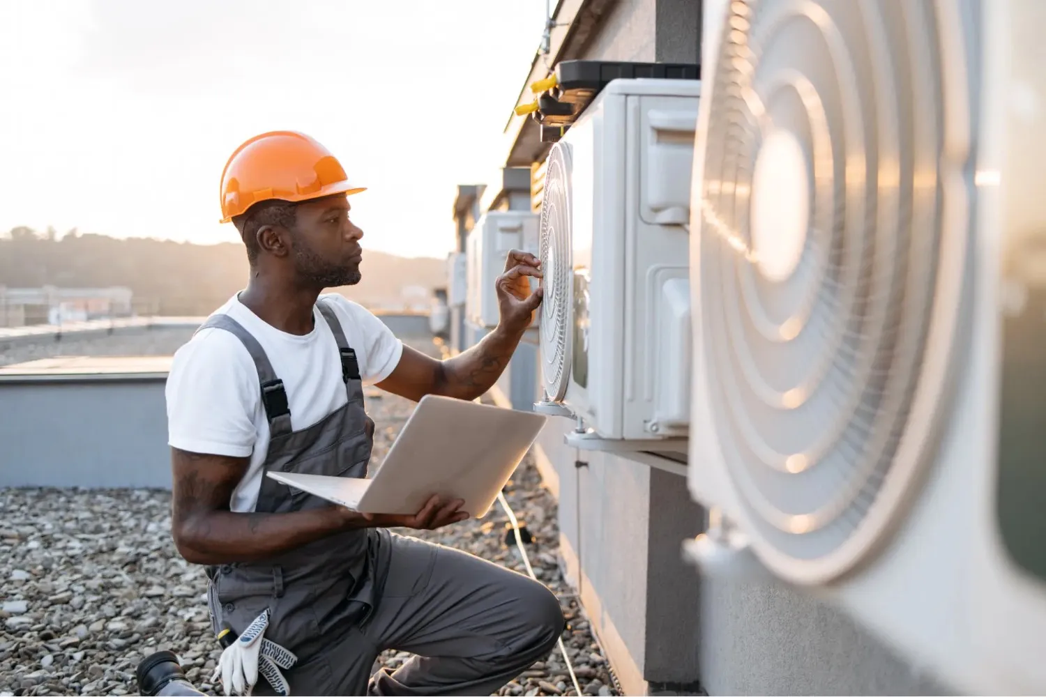 Technician using laptop to check HVAC.