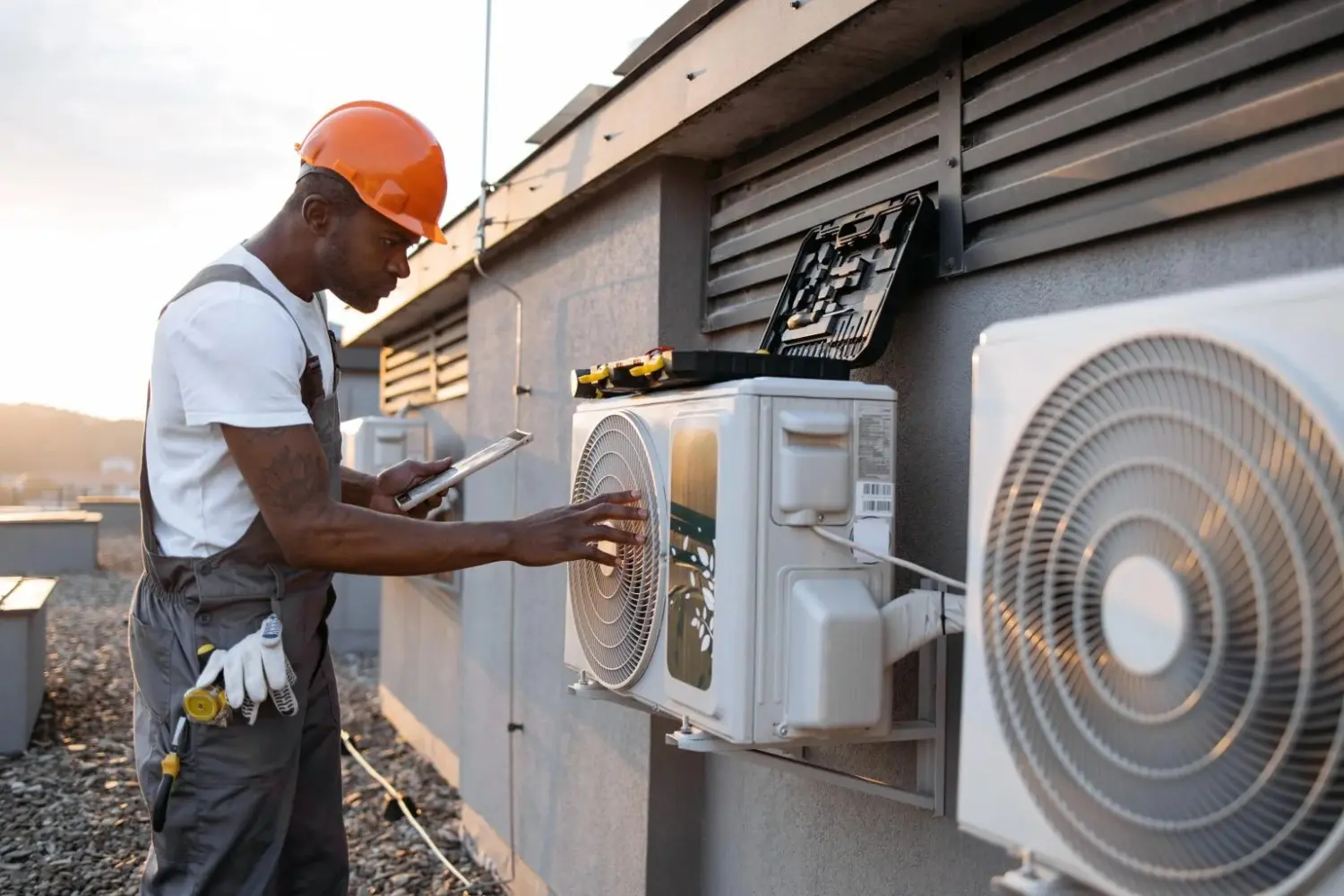 Technician inspects mini-split air conditioner outdoors.