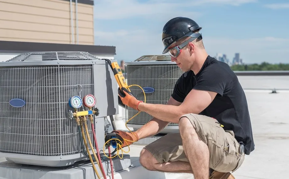 Technician servicing rooftop air conditioning unit.