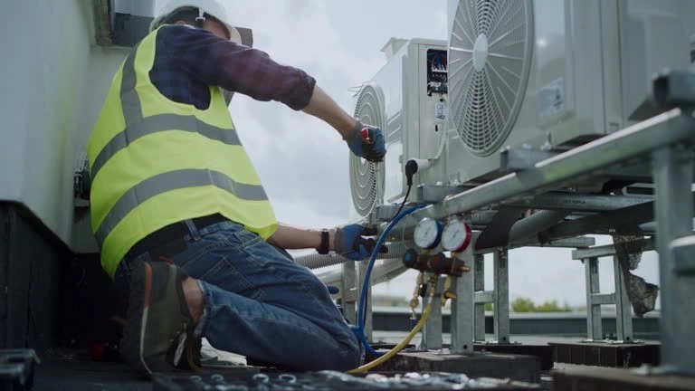 Technician works on rooftop mini-split condensers.