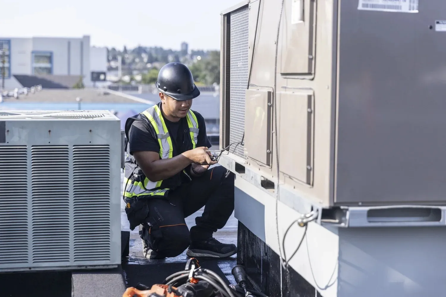 Technician servicing commercial rooftop HVAC unit.