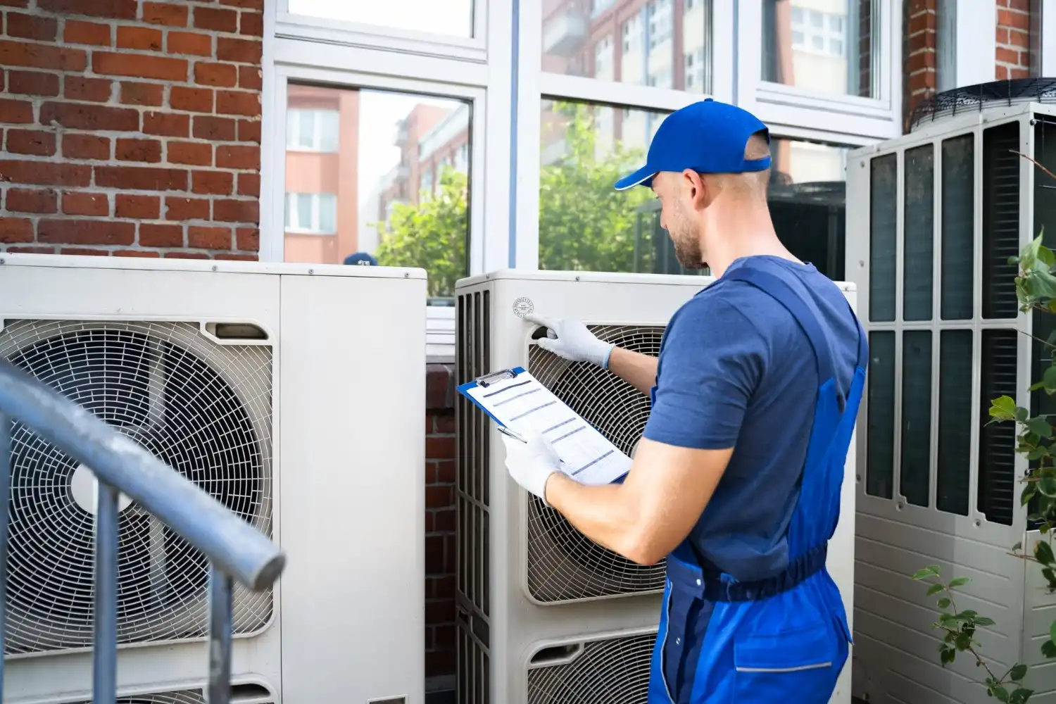 Technician inspecting outdoor AC unit with clipboard.