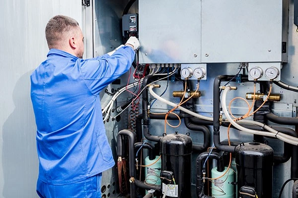 Technician wiring large commercial HVAC unit.