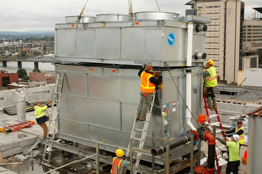 Workers installing a commercial cooling tower.