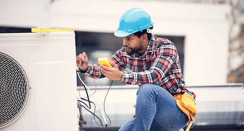 HVAC technician testing an outdoor unit.