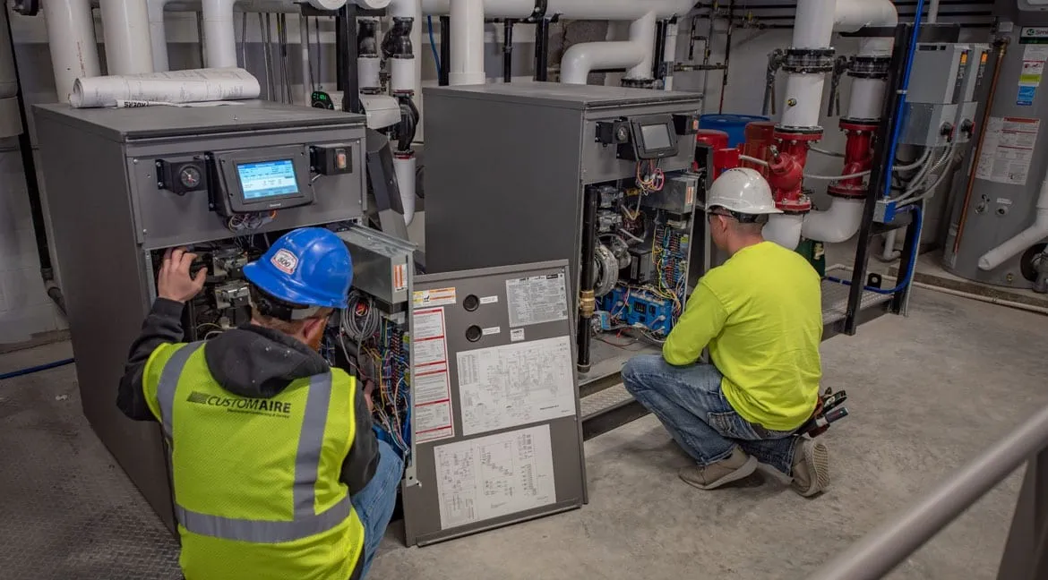 Two men servicing commercial HVAC units.