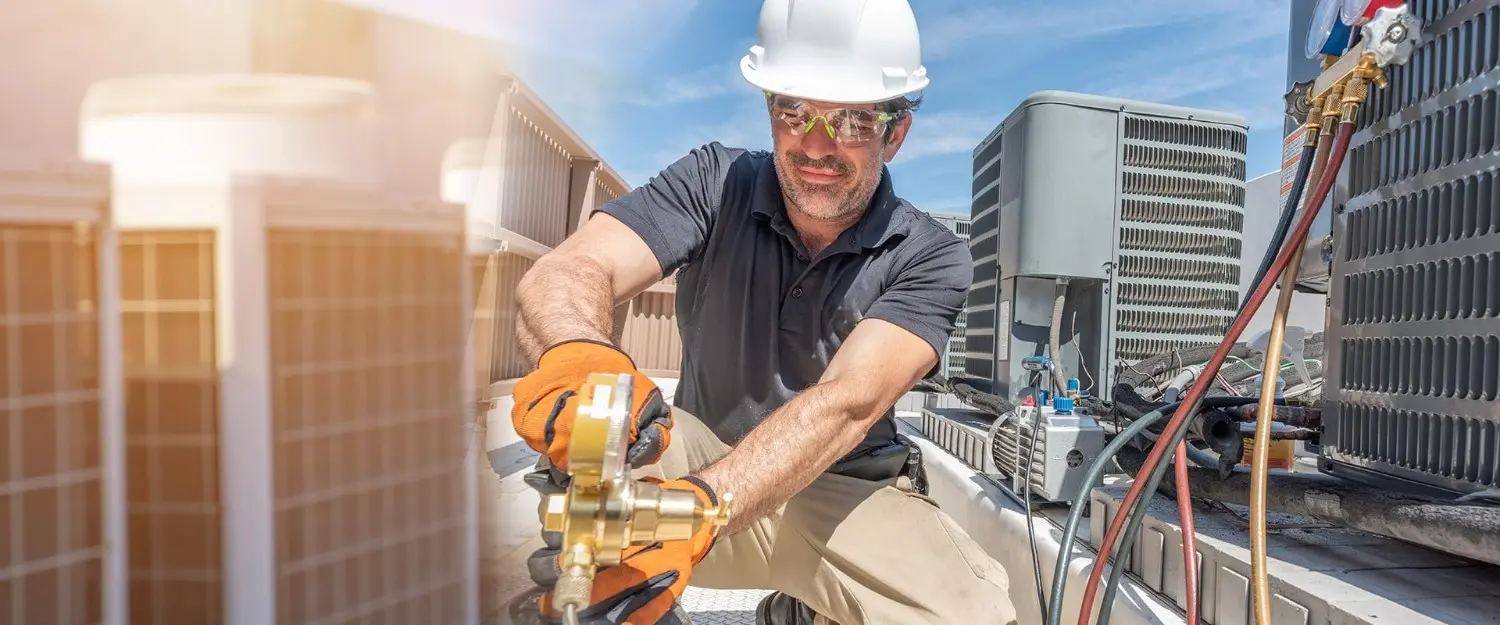 Technician checking HVAC units with gauges.