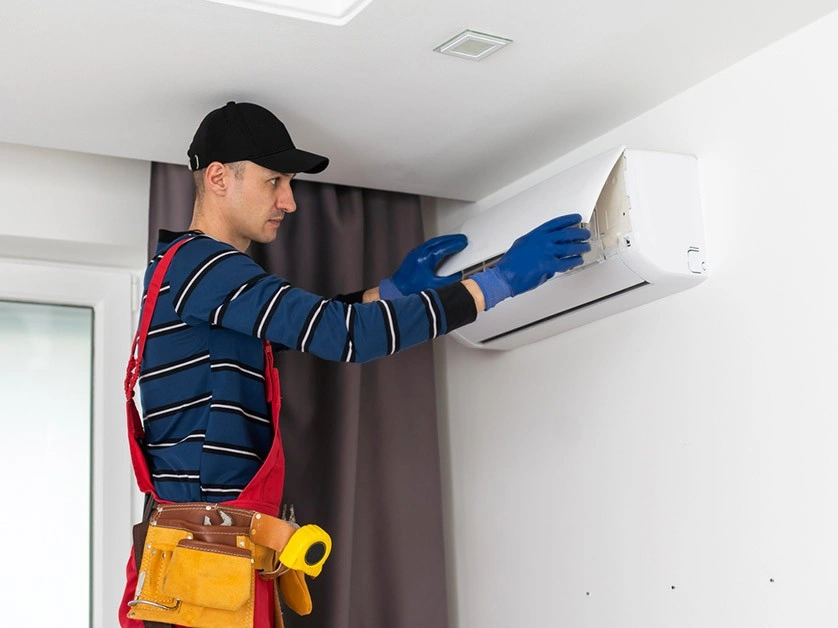 HVAC technician inspecting mini-split air conditioner