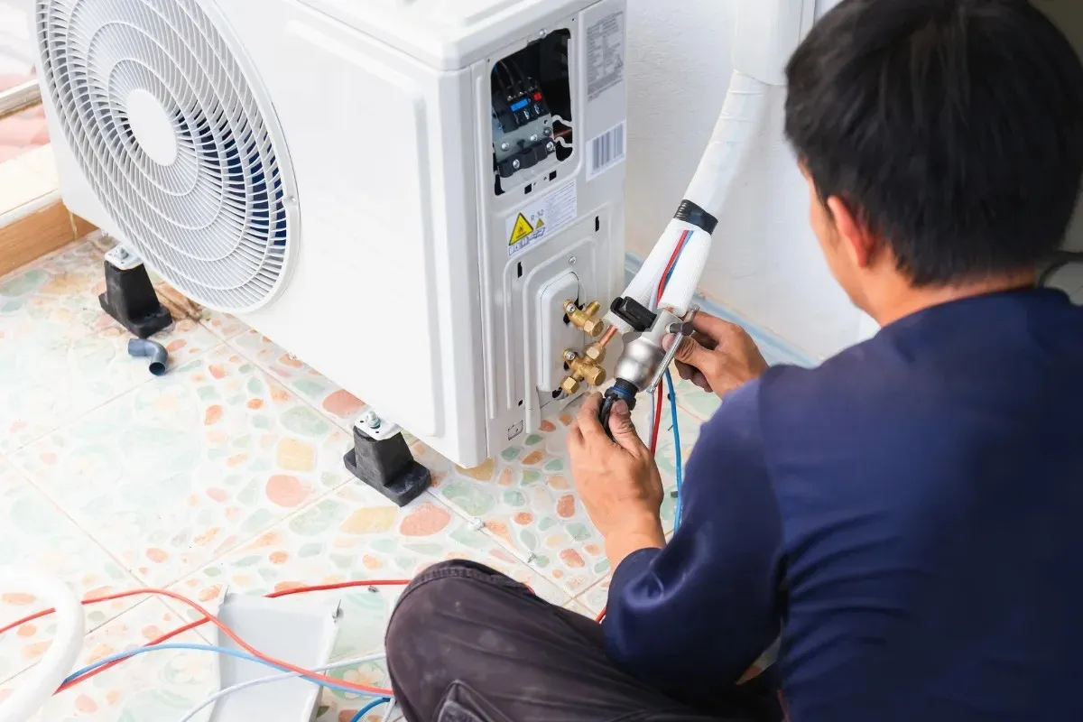 Technician connecting lines to mini-split AC