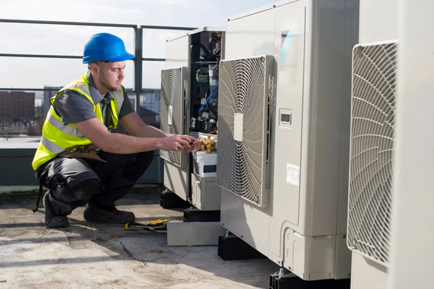 Technician repairs commercial rooftop HVAC unit