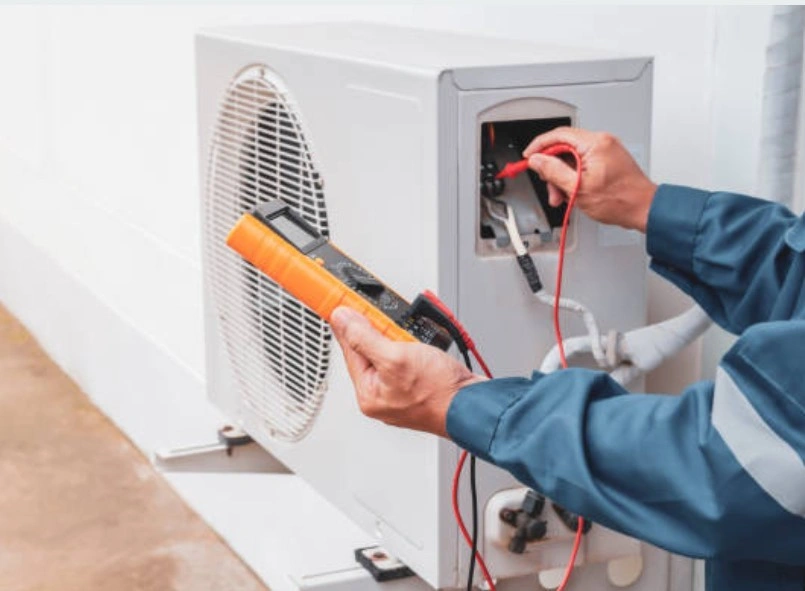 Technician measuring voltage on outdoor AC unit