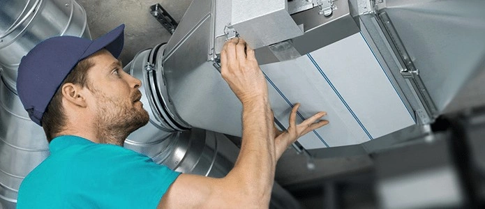 Man installing HVAC zoning damper.